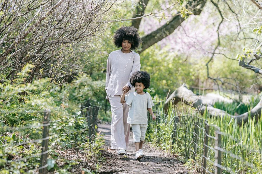 A mother and daughter walking on a park path